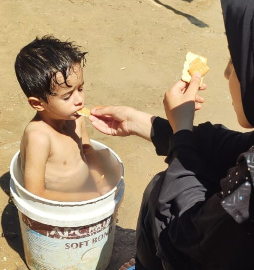 photo of Omar being bathed in a bucket