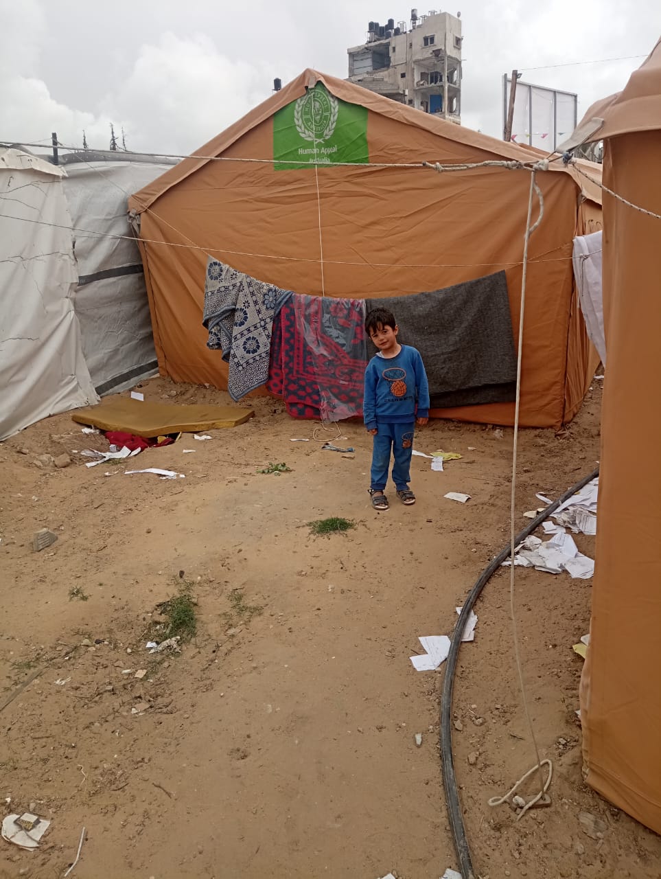 photo of Omar standing behind the tents